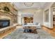 Inviting living room with a stone fireplace, wood floors, and an open layout leading to the kitchen at 2597 Oak Vista Ct, Castle Rock, CO 80104