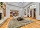 Open-concept living room with hardwood floors, stone fireplace, and views of the kitchen and dining areas at 2597 Oak Vista Ct, Castle Rock, CO 80104