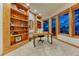 Bright office featuring custom wood built-in shelving, large windows, and plush carpeting at 2597 Oak Vista Ct, Castle Rock, CO 80104