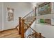 A staircase with custom metal and wood banisters, decorative window and hardwood floors at 2597 Oak Vista Ct, Castle Rock, CO 80104