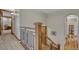 Upstairs hallway featuring wood banisters with metal accents and an arched doorway at 2597 Oak Vista Ct, Castle Rock, CO 80104