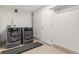 Practical laundry room with modern washer and dryer, tile floor, and storage at 7579 Jay Ct, Arvada, CO 80003