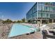 Outdoor pool area with clear water, lounge chairs, and a view of the modern building at 4200 W 17Th Ave # 508, Denver, CO 80204