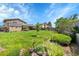 Expansive backyard featuring a lush green lawn, mature trees, and a charming garden area with decorative elements at 9225 Lowell Blvd, Westminster, CO 80031