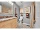Neutral-toned bathroom featuring a marble vanity, decorative mirror, and shower with framed art at 9225 Lowell Blvd, Westminster, CO 80031