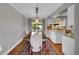 Bright dining room with wood floors, long table, decorative rug and lighting, next to modern kitchen at 9225 Lowell Blvd, Westminster, CO 80031