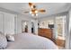 Warm primary bedroom with ceiling fan, wooden dresser, and ensuite bathroom with walk-in shower at 9225 Lowell Blvd, Westminster, CO 80031