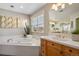 Bright bathroom featuring a large soaking tub and sleek vanity with a window at 6584 S Sedalia St, Aurora, CO 80016