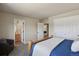 Bedroom with ensuite bathroom and closet, showcasing neutral paint, carpeting, and natural wood door frames at 6584 S Sedalia St, Aurora, CO 80016