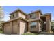 Two-story home with tan stucco exterior, two-car garage, well-manicured lawn, and front entrance at 6584 S Sedalia St, Aurora, CO 80016