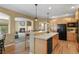 Bright kitchen with bar seating and black appliances at 6584 S Sedalia St, Aurora, CO 80016