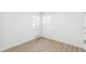 Bright bedroom with clean, white walls, a large window, new vinyl flooring, and neutral-colored paint at 1023 S Alcott St, Denver, CO 80219