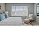 Bright bedroom showcases a comfortable bed, accent chair, and ample natural light from the large window at 13322 Meadow Park Ln, Broomfield, CO 80020