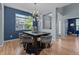 Elegant dining room with modern chandelier, hardwood floors, large window and blue accent wall at 13322 Meadow Park Ln, Broomfield, CO 80020