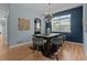 Bright dining room featuring wood floors, stylish chairs, a modern light fixture and an adjacent kitchen at 13322 Meadow Park Ln, Broomfield, CO 80020