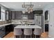 Modern kitchen featuring an island, stainless steel appliances, dark cabinets, tiled backsplash, and hardwood floors at 13322 Meadow Park Ln, Broomfield, CO 80020