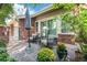 Relaxing backyard stone patio featuring comfortable seating, an umbrella, and lush landscaping at 2552 E Alameda Ave # 74, Denver, CO 80209