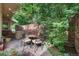 Outdoor patio area with a round table and chairs, brick walls, and privacy landscaping at 2552 E Alameda Ave # 74, Denver, CO 80209