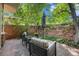 Private outdoor patio area with comfortable seating and lush greenery with a brick surround at 2552 E Alameda Ave # 74, Denver, CO 80209