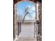 View of the backyard, seen through an arched brick entry, showcasing a snow-covered landscape at 2317 Primo Rd # A, Highlands Ranch, CO 80129