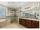 Bright bathroom with a glass enclosed shower, tub, tile flooring and a granite countertop at 2317 Primo Rd # A, Highlands Ranch, CO 80129