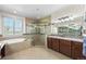 Bright bathroom features a double vanity, a large glass shower, and soaking tub with tiled walls at 2317 Primo Rd # A, Highlands Ranch, CO 80129