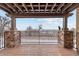 Covered deck with stone columns, metal railings and a pergola overlooking a snowy landscape with a sculpture at 2317 Primo Rd # A, Highlands Ranch, CO 80129