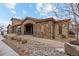 Charming exterior showcasing stone facade, arched entry, and professionally landscaped grounds at 2317 Primo Rd # A, Highlands Ranch, CO 80129