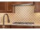 A beautiful close-up of the kitchen backsplash and gas range cooktop at 2317 Primo Rd # A, Highlands Ranch, CO 80129