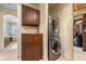 Efficient laundry area with stacked washer and dryer and storage cabinets at 2317 Primo Rd # A, Highlands Ranch, CO 80129