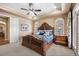 Tranquil main bedroom with a decorative bedframe, tray ceiling, and arched windows at 2317 Primo Rd # A, Highlands Ranch, CO 80129