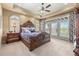 Bedroom with tray ceilings and balcony doors with wooded view at 2317 Primo Rd # A, Highlands Ranch, CO 80129