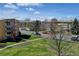 Community street view showcasing well-maintained landscaping and residential buildings under a sunny sky at 9180 E Center Ave # 9D, Denver, CO 80247