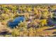 Breathtaking aerial view of a pond and lush fall foliage creating a serene and picturesque setting at 7162 S Fillmore Cir, Centennial, CO 80122