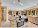 Open kitchen with stainless appliances, center island with breakfast bar, and adjacent living room at 7162 S Fillmore Cir, Centennial, CO 80122