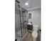 Modern bathroom with sleek black-framed glass shower, floating vanity, and arched illuminated mirror at 17605 E Temple Dr, Aurora, CO 80015