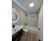 Modern bathroom with neutral tile and a black faucet, and dark wood vanity at 17605 E Temple Dr, Aurora, CO 80015
