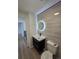 Modern bathroom featuring floating vanity with black accents and a large, illuminated round mirror at 17605 E Temple Dr, Aurora, CO 80015