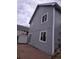 Side view of a gray home showcasing windows, brick patio and siding at 17605 E Temple Dr, Aurora, CO 80015