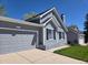 Charming home featuring a two-car garage, black shutters, and well-maintained lawn at 17605 E Temple Dr, Aurora, CO 80015