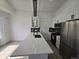 Modern kitchen featuring white cabinets, a stylish black backsplash, and stainless steel appliances at 17605 E Temple Dr, Aurora, CO 80015