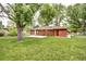 Beautiful backyard with lush lawn, brick house, and mature trees offering shade and privacy at 6340 Quay St, Arvada, CO 80003