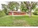 Large backyard with lush grass, brick house, and mature trees, perfect for outdoor activities at 6340 Quay St, Arvada, CO 80003