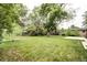 Lush backyard featuring a well-manicured lawn and mature trees, providing a serene outdoor space at 6340 Quay St, Arvada, CO 80003