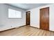 Bedroom with wood-look floors, and natural light streaming through the window at 6340 Quay St, Arvada, CO 80003