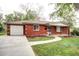 Charming single story brick home featuring a paved walkway, attached garage, and well-maintained lawn at 6340 Quay St, Arvada, CO 80003