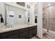 Bathroom boasting dual sinks, granite countertop, dark cabinets, and a walk-in tiled shower with glass door at 14419 Dahlia St, Thornton, CO 80602
