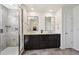 Bathroom featuring a double vanity with granite countertops, stylish mirrors, and a modern glass shower at 14419 Dahlia St, Thornton, CO 80602