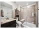 Bathroom showcasing a tiled shower, glass door, a toilet with a wooden shelf, and a granite countertop sink at 14419 Dahlia St, Thornton, CO 80602