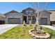 Charming home featuring a two-car garage and a well-manicured lawn with a newly planted tree in the front yard at 14419 Dahlia St, Thornton, CO 80602